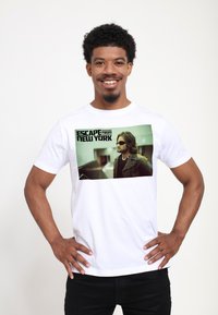 Hvid bomulds t-shirt med et trykt billede af en mand med solbriller, med fed tekst der står "ESCAPE from NEW YORK" ovenfor grafikken.
