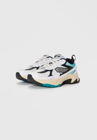 Zapatillas deportivas blancas con detalles en negro y aqua, parte superior de malla texturizada, suela acolchada y elementos de diseño pronunciados.