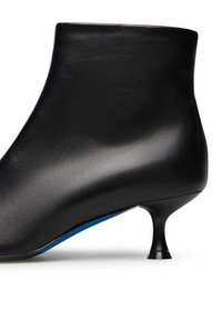 Stivale alla caviglia in pelle nera dal design elegante, con tacco sottile e appuntito e un dettaglio blu in contrasto lungo la suola.