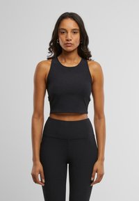 Svart, tettsittende avkortet tanktopp med rund utringning og ermeløs design, laget av glat og elastisk materiale.