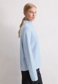 Maglione a maniche lunghe di colore azzurro chiaro con collo alto, realizzato in morbido tessuto a maglia; presenta una vestibilità comoda e una texture a coste.