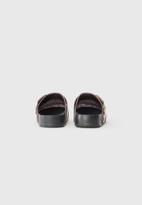 Black rubber sandals with a textured, multicolored strap. Open toe design with a flat sole and adjustable closure on the side.