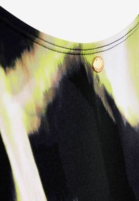 Tessuto nero e verde con un motivo, caratterizzato da una texture liscia e un bottone in metallo dorato all'collo.