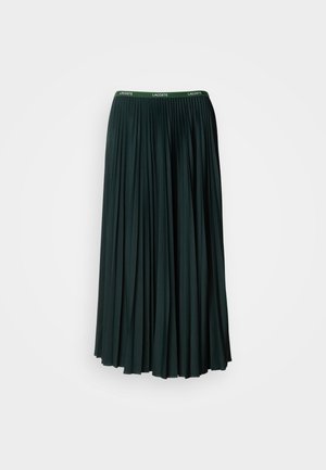Saia longa plissada em verde escuro com uma cintura larga que apresenta o nome da marca "LACOSTE" em letras verdes contrastantes.