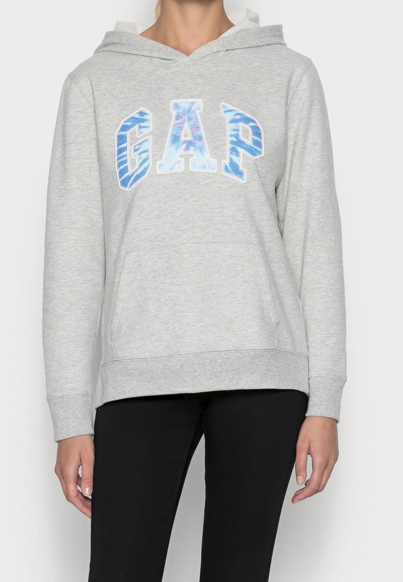 Felpa grigia con tasca a marsupio, interno bianco e logo "GAP" in blu e bianco. Maniche lunghe con polsini a coste. Tessuto morbido.