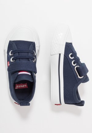 Marineblaue Kleinkind-Sneaker mit weißen Gummikappen an den Zehen, Klettverschlüssen, Schnürsenkeln und weißen Sohlen mit schwarzen Streifen.