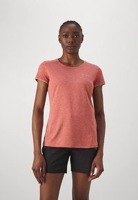 Kortärmad, figursydd t-shirt i melerad korallfärg, tillverkad av andningsbart tyg, med en liten logga på vänster bröst. Matchas med svarta shorts.