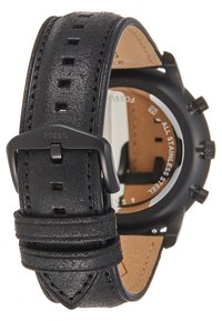 Schwarzes Lederarmband mit strukturierten Oberflächen und mehreren Einstanzlöchern, ausgestattet mit einer schwarzen Metallschnalle. Sichtbares Gehäuse aus Edelstahl.