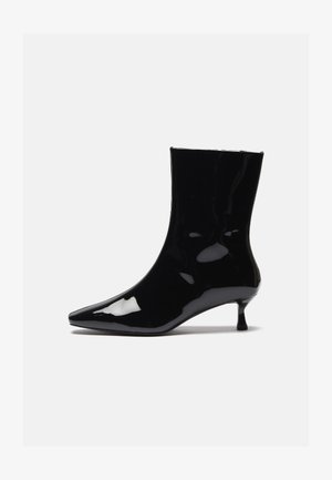 Czarne lakierowane botki za kostkę z wysmukloną czubkiem, dopasowanym kształtem i małym, cienkim obcasem. Gładka tekstura i wysoki połysk.