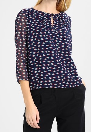 Blusa blu navy con motivo a pesci in blu e rosso, scollatura rotonda con apertura a forma di chiave, maniche sheer a tre quarti e vestibilità comoda.