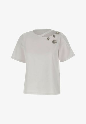 Fehér, rövid ujjú blúz aszimmetrikus nyakkivágással, amelyen az jobb vállnál öt ezüst ékszer díszítés található.