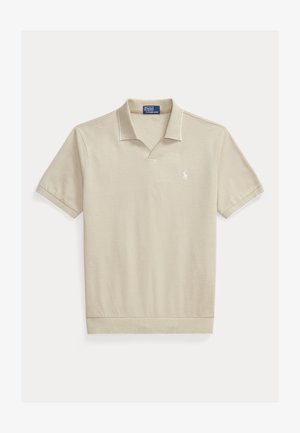 Beżowa koszulka polo z krótkim rękawem, prążkowanym kołnierzykiem, otwartym dekoltem w kształcie litery V i małym białym haftowanym logo na lewej piersi.