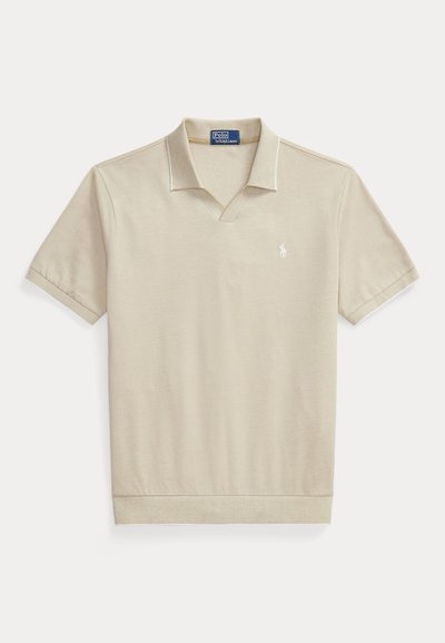 Μπεζ πόλο με κοντό μανίκι, ριμπ γιακά, ανοιχτό V-λαιμό και μικρό λευκό κεντητό λογότυπο στο αριστερό στήθος.