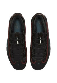 Svarta träningsskor med röda accenter, med ovandel i mesh, runda snören och en texturerad sula. Tydlig varumärkeslogotyp på tungan.