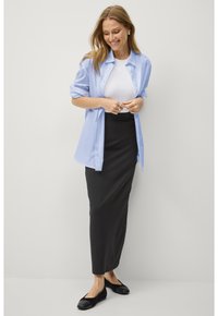 Helles blaues Button-Down-Hemd, weißes T-Shirt, schwarze Maxiröcke, schwarze Ballerinas. Lässiges Outfit mit lockerer Passform und geschichteten Texturen.