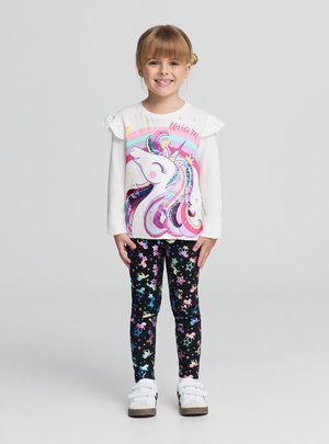 Camicia bianca a maniche lunghe con maniche arricciate e grafica colorata di unicorno, abbinata a leggings neri decorati con stelle pastello e unicorni.