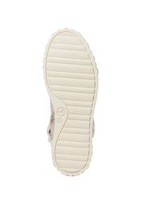 Suela de zapato, de goma, color blanco roto, texturizada con líneas horizontales y bordes ondulados, con un logo circular cerca del talón.