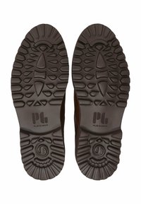 Braune Schuhsohlen mit ausgeprägten Grip-Mustern, die eine strukturierte Oberfläche und ein Logo-Element aufweisen. Das Design legt Wert auf Traktion und Stabilität.