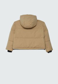 Veste matelassée beige avec capuche, manches longues et poignets intérieurs noirs, vue de dos sur un fond gris clair.