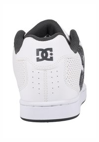Witte leren sneaker met een zwart gaas paneel en perforaties. Inclusief een zwart logo detail op de hak en een witte rubberen zool.