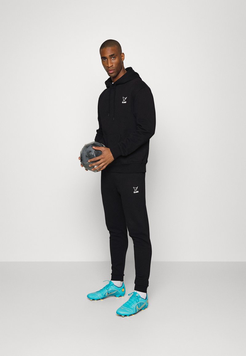 Herren Trainingsanzüge | KLABU BUTTERFLY PANTS Jogginghose black/schwarz - TJ97843 Herren Trainingsanzüge | KLABU BUTTERFLY PANTS Jogginghose black/schwarz - TJ97843