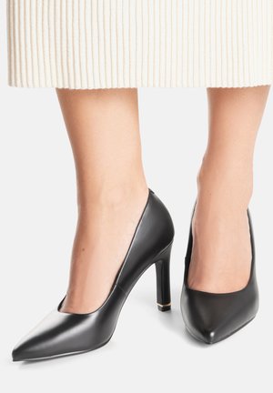 Czarne skórzane buty na wysokim obcasie, z szpiczastym noskiem i gładką fakturą. Obcasy mają około 7,5 cm wysokości i subtelny złoty akcent.