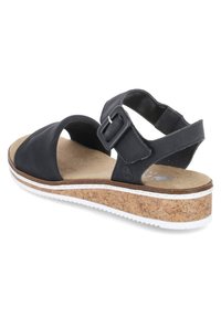 Black sandal with two wide straps and a side buckle, cork midsole, white rubber sole, and soft textured insole.