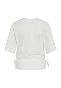 Hvit kortermet topp laget av myk bomull. Har knyter på sidene og en avslappet passform. Enkelt design uten mønstre eller grafikk.