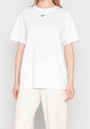 T-shirt blanc à manches courtes en coton, avec un petit logo Nike noir sur la poitrine. Coupe décontractée avec un col rond.