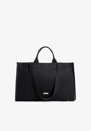 Zwarte rechthoekige tas met korte en lange handvatten, gestructureerd ontwerp en een klein metalen merkembleem aan de voorkant in het midden.