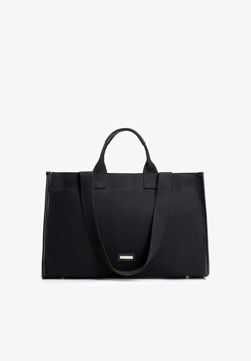 Czarna prostokątna torba typu tote z krótkimi i długimi uchwytami, o strukturalnym kształcie oraz małą metalową metką z logo marki na środku przodu.