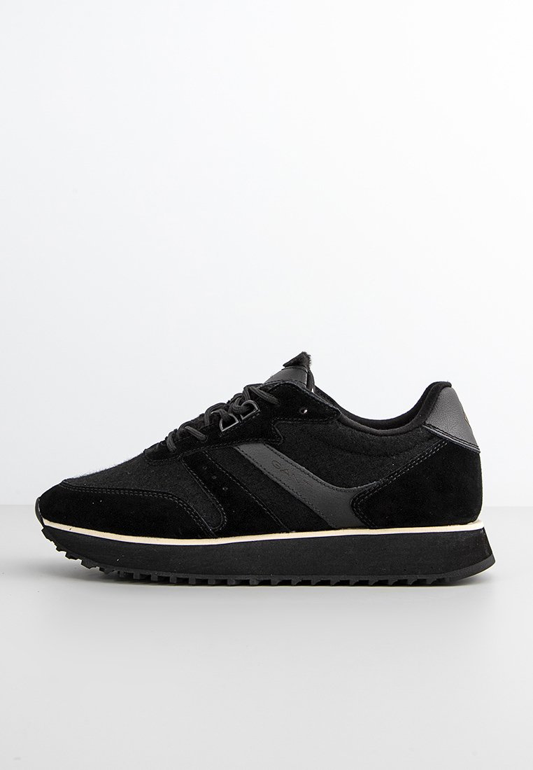 Zapatillas deportivas negras hechas de ante y cuero, con un diseño de cordones, superficie texturizada y una suela de goma blanca contrastante.