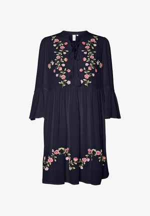 Mörkblå klänning med blommig broderi i rosa och grönt, med hög halsringning, fransdetaljer och trumpetärmar. Utställd silhuett.