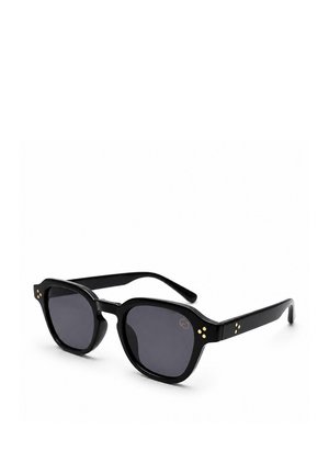 Schwarz rahmige Sonnenbrille mit dunklen Gläsern und kleinen goldenen Punkten an den Ecken und Bügeln auf weißem Hintergrund.