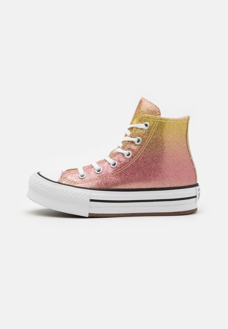 Wysokie trampki z gradientowym metalicznym wykończeniem w kolorach różowym i złotym, białymi sznurówkami oraz gumową podeszwą w czarne paski. Teksturowana górna powierzchnia.