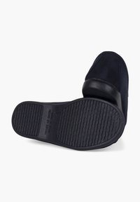 Črne zamshek čevlje za prosto čas, ki vključujejo teksturiran črn gumijast podplat. Oblika ima nizek profil in minimalne šive.