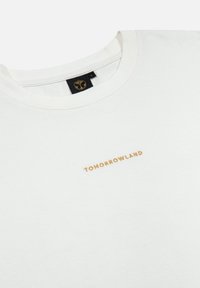 Witte katoenen T-shirt met "TOMORROWLAND" geborduurd in goud. Klassiek crew neck ontwerp met een zachte textuur en een minimalistische stijl.