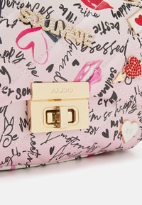 Borsa a tracolla trapuntata rosa con accessori dorati, caratterizzata da un'insegna "SOULMATE" e decorazioni tra cui cuori e labbra.