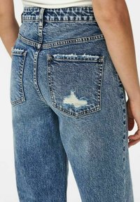 Jeans in denim blu sbiadito con vita alta, caratterizzati da tasche posteriori strappate e orli sfrangiati per un look casual. Tessuto testurizzato con leggere variazioni.