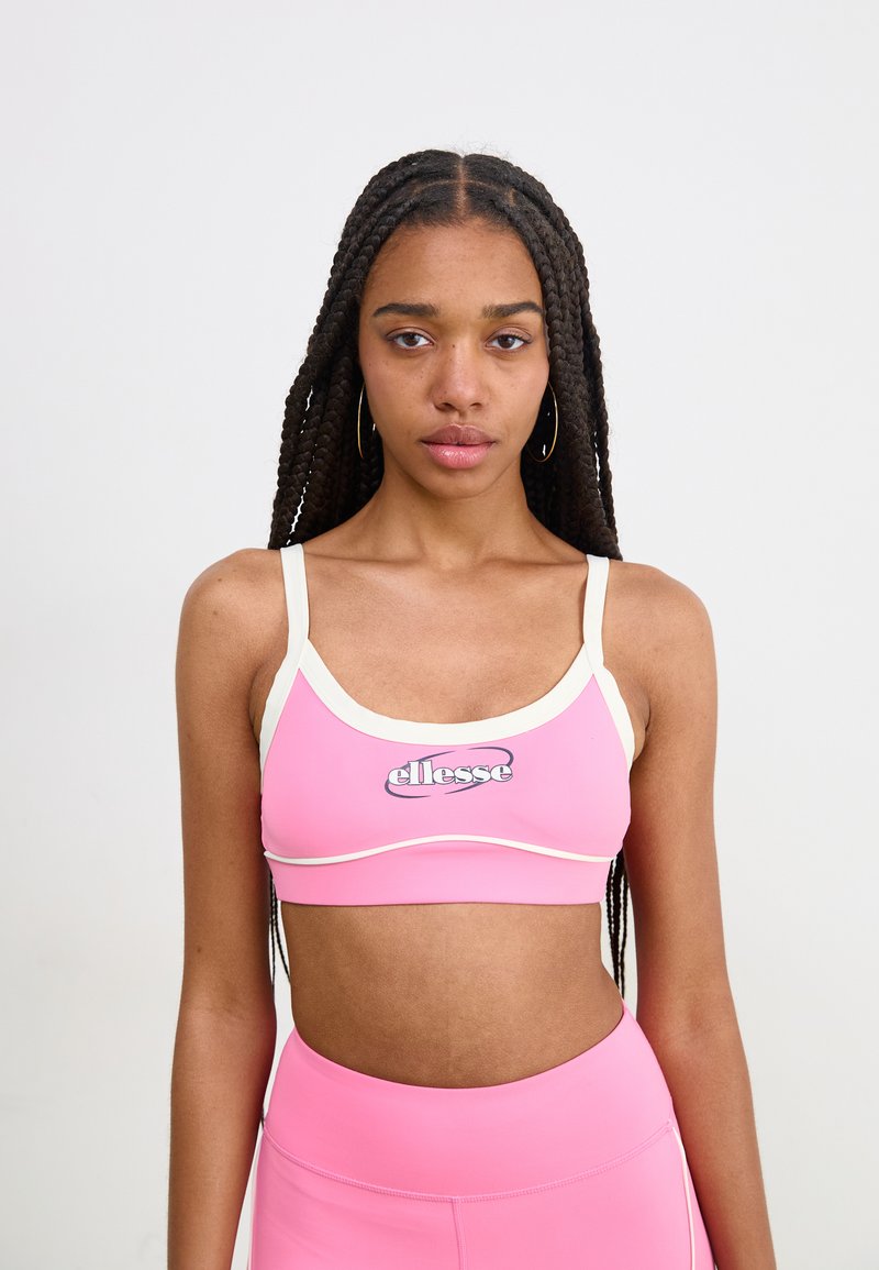 Ružový športový bralet s bielym okrajom, na prednej strane s logom "ellesse". Hladká textura, priliehavý strih a nastaviteľné ramienka.