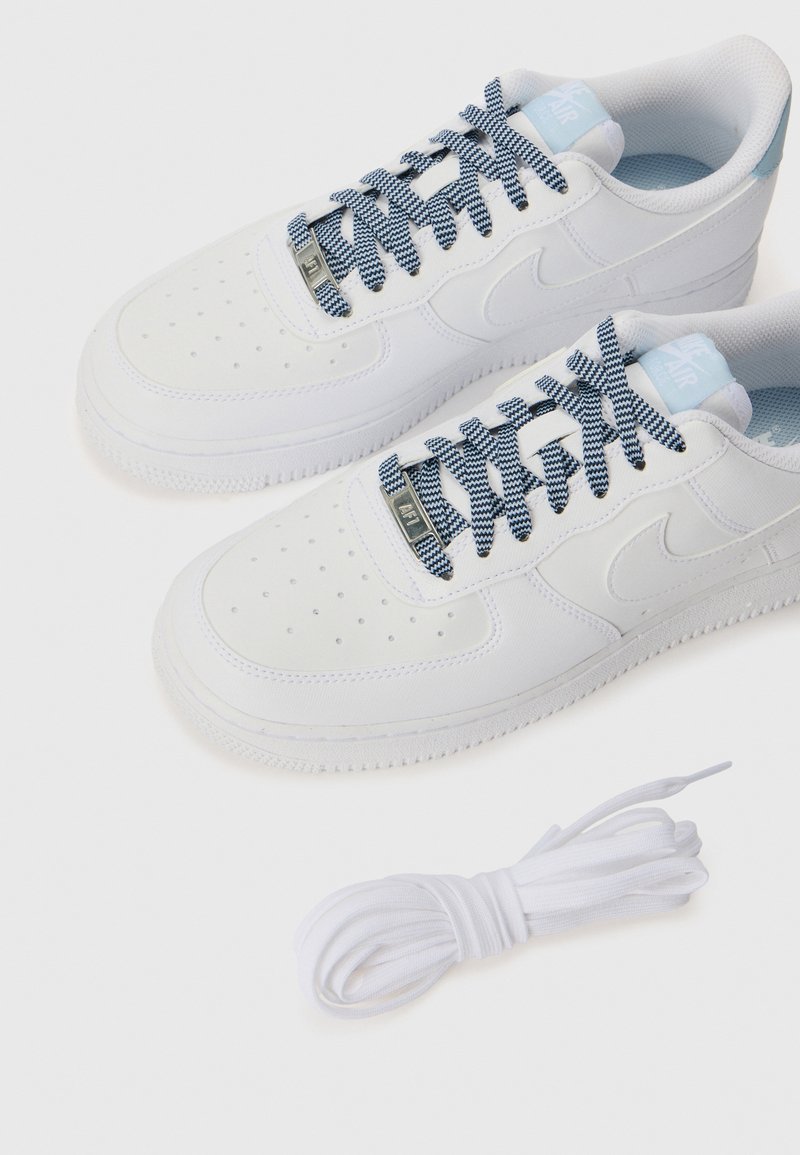 Białe sneakersy Nike Air Force 1 z teksturowanym materiałem, perforowaną detalami, niebieskimi i białymi sznurówkami w wzory oraz dodatkowym białym sznurkiem w komplecie.