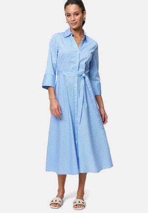 Blauw-wit gestreepte shirtjurk, knie-lang, korte mouwen met knoopsluiting aan de voorkant, taille met strik, gecombineerd met witte sandalen.