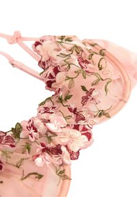 Rosa spets-bh med blommönster i bordeaux och grön, med en vågig kant, justerbara axelband och en liten båtdetalj.