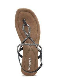 Sandal plana negra con suela marrón acolchada, con tiras cruzadas adornadas con pequeños adornos metálicos y hebilla lateral ajustable.