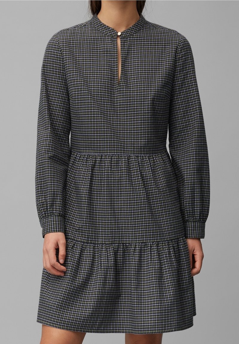 Robe à carreaux bleu foncé et blanc, manches longues, col avec ouverture en œillet, jupe froncée. Tissu en coton, coupe décontractée.