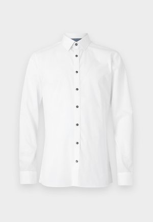 Biela košeľa s dlhým rukávom z bavlny, s klasickým golierom, čiernymi gombíkmi a bočnými záševkami na tvarovanie. Hladká textúra a strih prispôsobený postave.