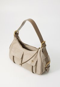 Šviesiai ruda zomšinė petinė krepšys su užtrauktuku, dviem priekinėmis kišenėmis ir nuimamu odiniu dirželiu. Auksinės spalvos detalės pabrėžia dizainą.