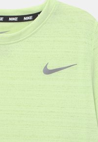 Světle zelené textilní tričko Nike s kulatým výstřihem, na hrudi s šedým logem Nike a měkkým, texturovaným materiálem.