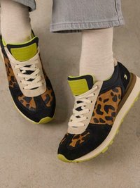 Zapatillas con estampado de leopardo negro y marrón, con cordones crema, detalles en verde y una suela acolchada. Cuenta con un material de ante texturizado.
