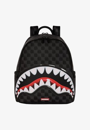 Zaino nero a quadri con una bocca aperta di squalo rossa grafica e denti bianchi affilati sulla tasca frontale, doppie cerniere e spallacci imbottiti.
